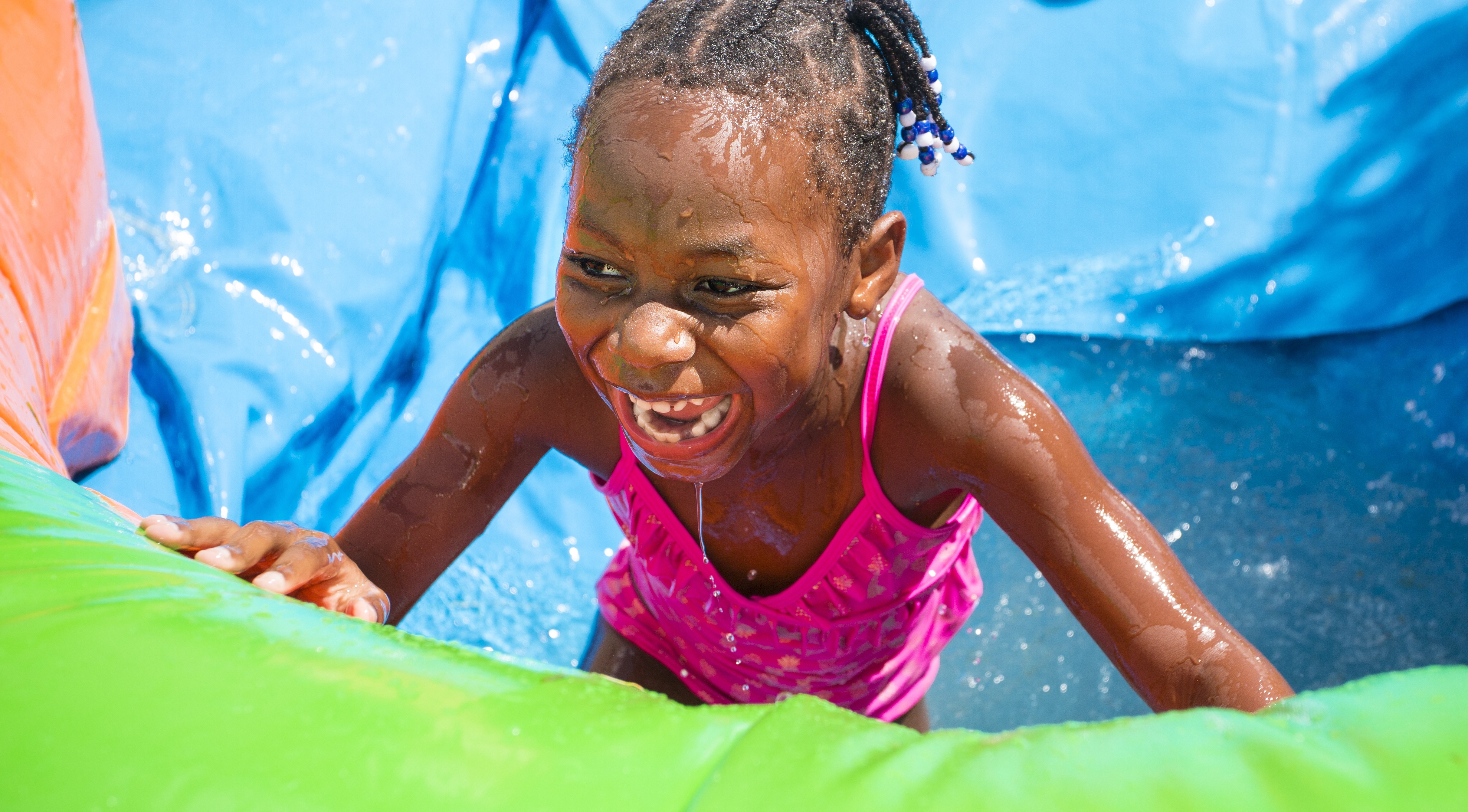 black girl in summer bathing suit water slide play activity safety