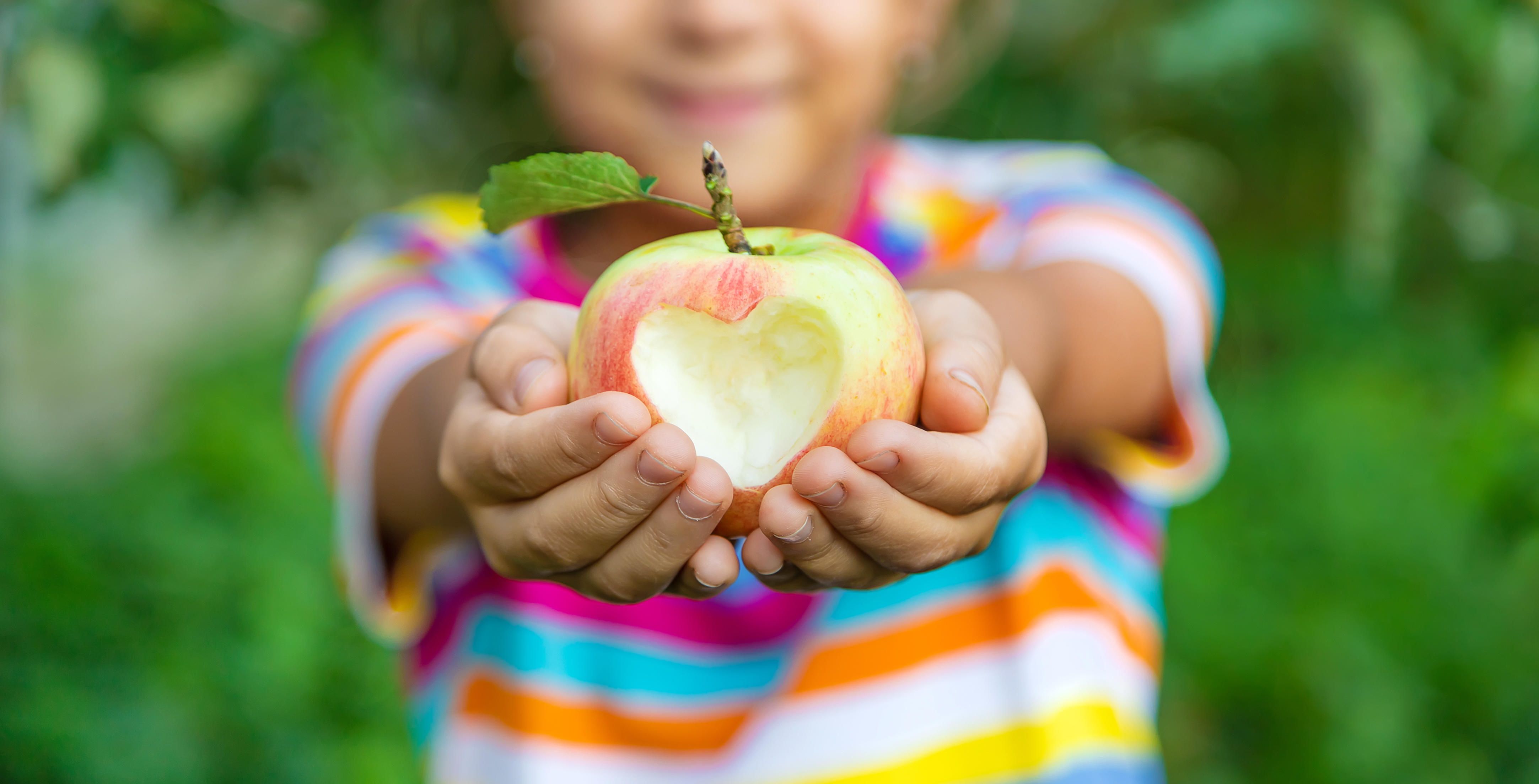 girl holding apple with cut out heart nutrition resources summer free food access