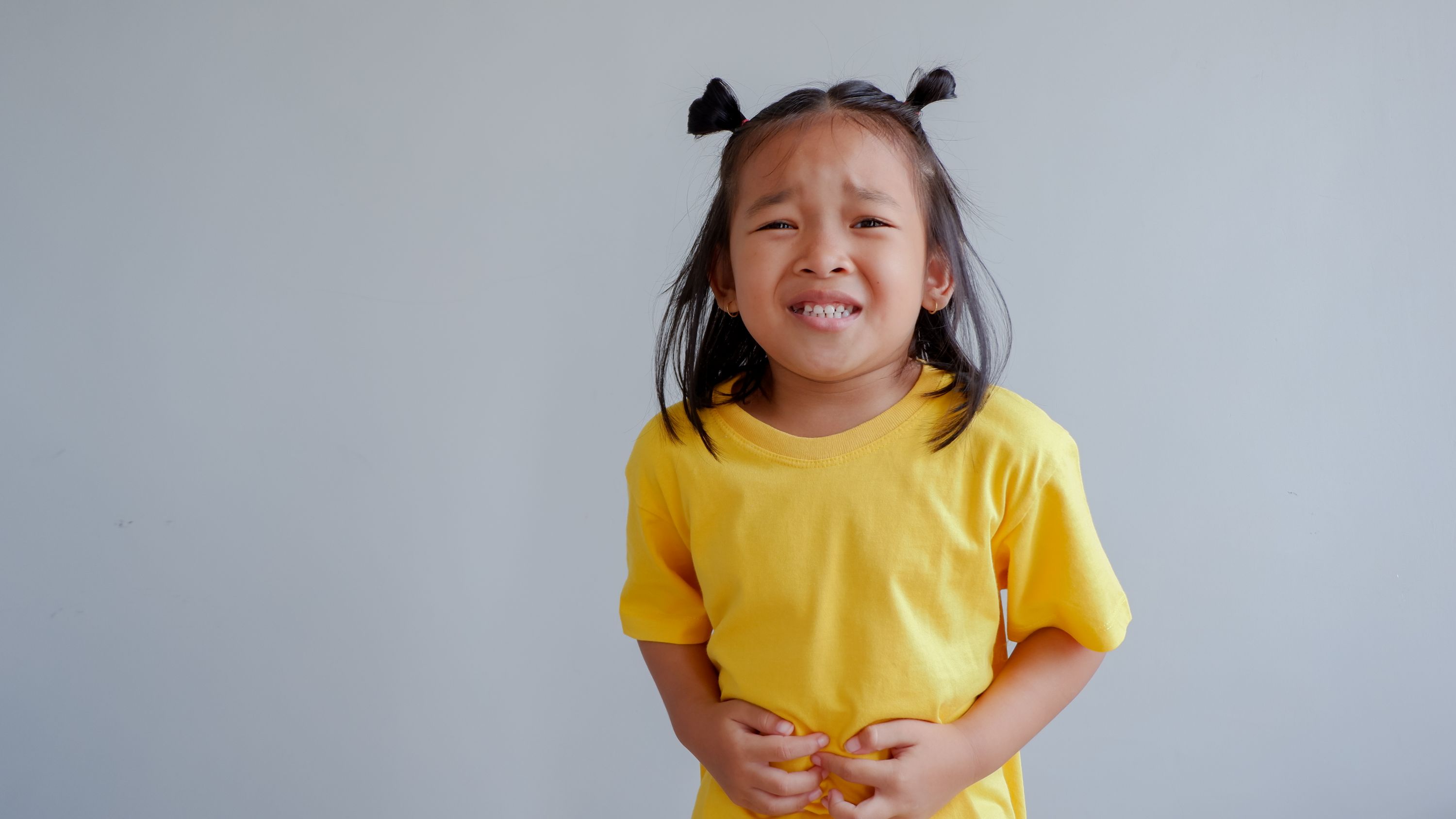 girl clutching her stomach in pain IBD IBS stomach pain ache tummy digestion