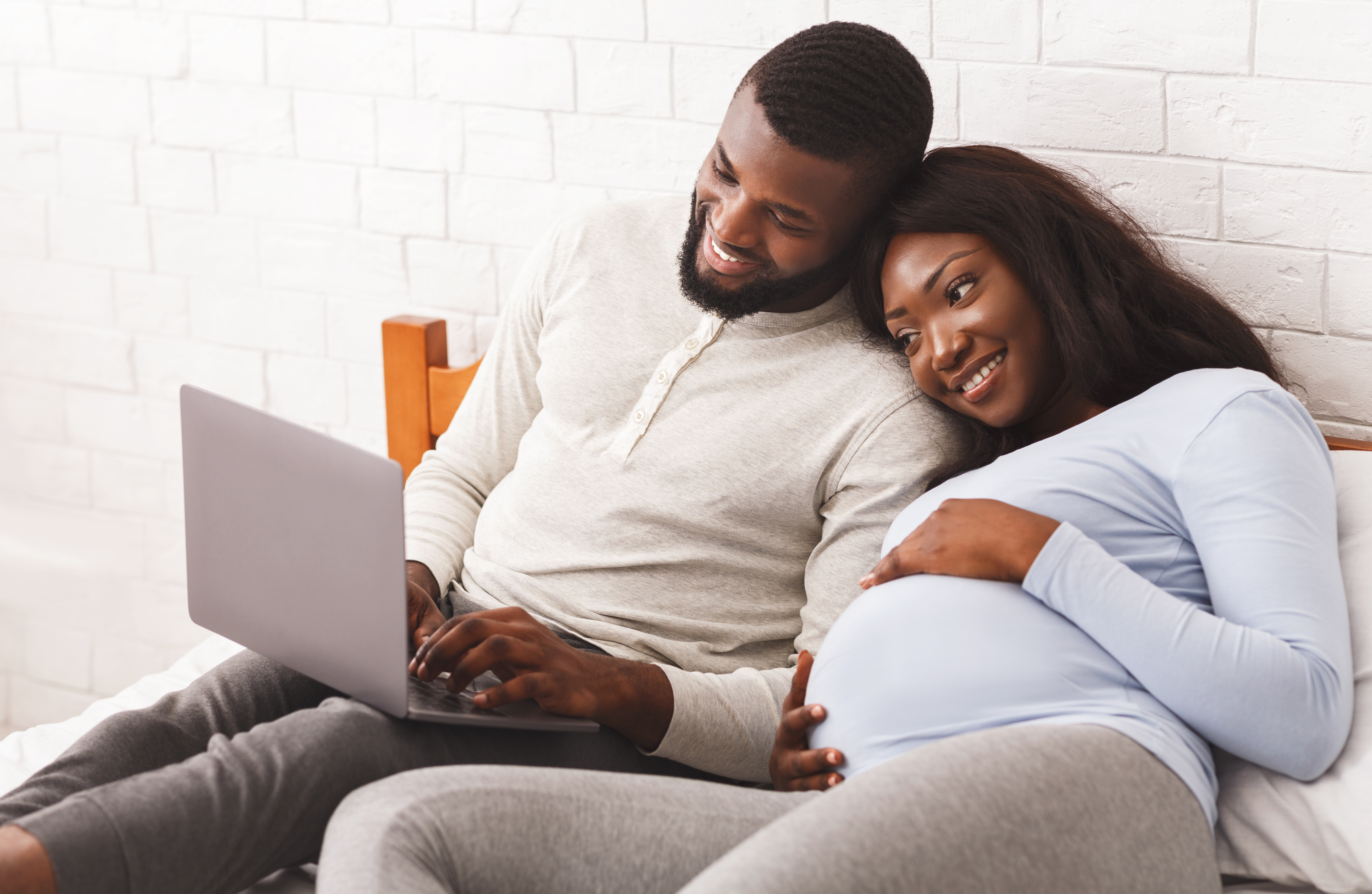 couple on computer attending online baby class expecting parent pregnant