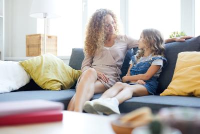 mom talking with young daughter on couch image