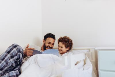 dad reading with little kid in bed